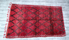 Discover the beauty of traditional Moroccan weaving with this antique Berber tribal rug. Featuring a captivating mix of geometric patterns and a warm, faded color scheme, this vintage piece tells a story of heritage and artistry. Each knot and weave is meticulously crafted by hand, ensuring a unique, heirloom-quality textile. The rugged yet soft wool construction makes it suitable for both high-traffic areas and cozy spaces. Whether layered over hardwood floors or used as a focal point in a minimalist setti