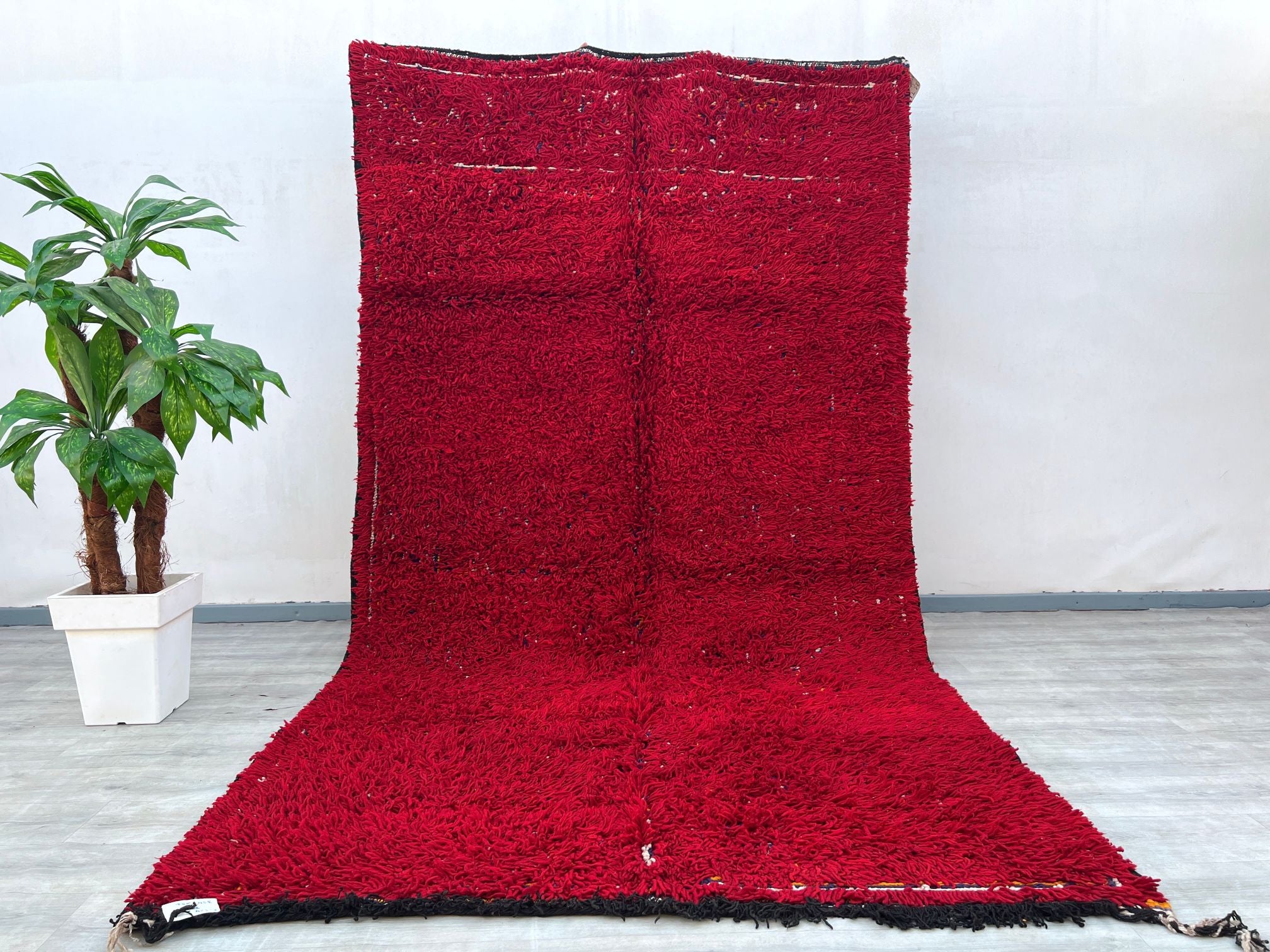 Elevate your home with this stunning handmade Moroccan Boujad rug, featuring a striking red and black tribal motif. Measuring 7x9 ft, this vintage wool rug is crafted using traditional Berber techniques, ensuring a soft yet durable texture. The bold geometric patterns and faded hues create a lived-in, bohemian aesthetic, perfect for eclectic or minimalist interiors. Its versatile design complements both modern and rustic spaces, adding warmth and texture. Whether used as an area rug or wall hanging, this pi