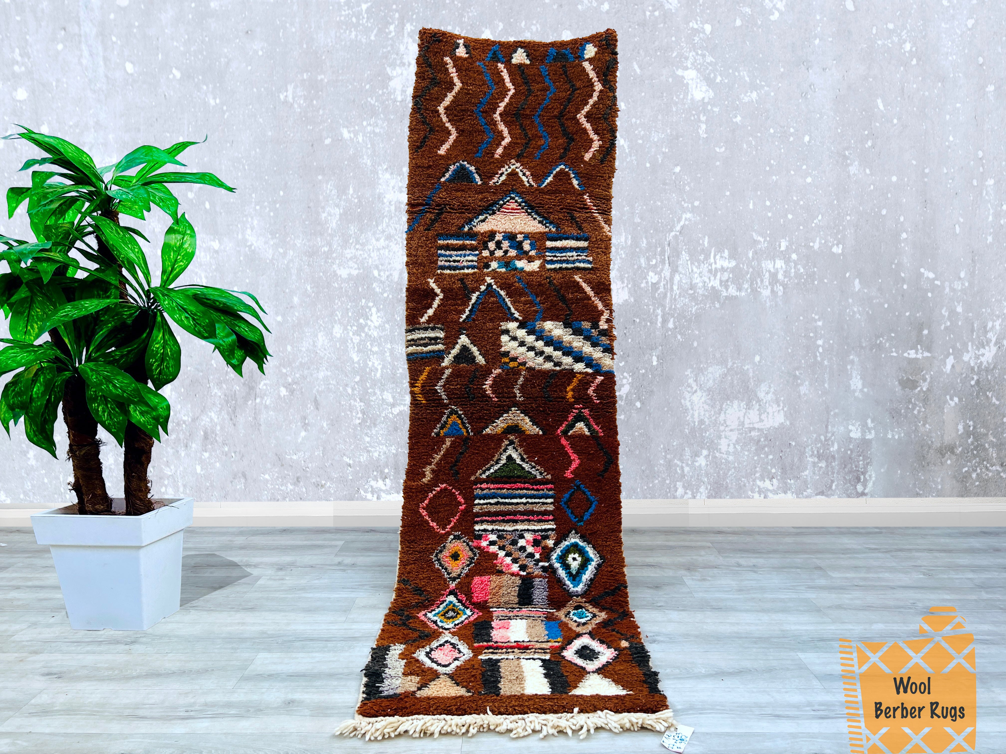 Enhance your space with this exquisite antique Moroccan wool runner, measuring 2.5 ft x 8.9 ft. Handcrafted using traditional Berber techniques, this corridor rug boasts a timeless tribal pattern in earthy brown hues, offering a rustic yet elegant touch. The high-quality wool ensures durability and softness underfoot, while the vintage wear adds authenticity. Perfect for hallways, kitchens, or beside beds, this handmade rug reflects Morocco’s rich weaving heritage. Its versatile design complements eclectic,