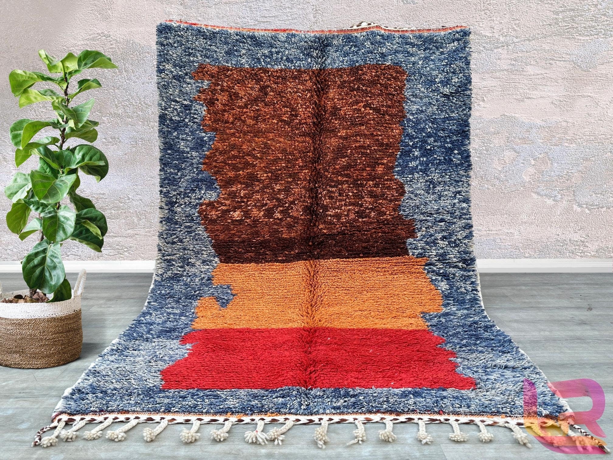 Enhance your home with this authentic handmade Moroccan Berber rug, featuring a bold, abstract design in rich, earthy tones. Woven using traditional techniques, this Azilal-style rug showcases a playful mix of colors and patterns, inspired by the artistic heritage of the Atlas Mountains. The plush, high-pile texture provides a luxurious feel underfoot, while the durable wool construction ensures long-lasting beauty. Ideal for bohemian, mid-century, or contemporary decors, this versatile area rug adds warmth