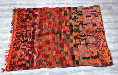 Discover the allure of Moroccan tribal decor with this handmade vintage Berber rug, featuring a captivating red and black checkered pattern. Originating from the Boujad and Azilal regions, this wool rug boasts artisanal knotting techniques and organic dyes, ensuring a unique, earthy aesthetic. The distressed vintage look adds rustic charm, complementing Scandinavian, bohemian, or global-inspired spaces. Its medium pile offers softness, while the durable weave stands up to daily use. A versatile piece for li