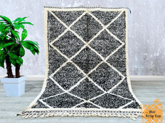 Bring a touch of Moroccan heritage into your home with this stunning black and white Beni Ourain rug. Handwoven by skilled artisans, this Berber carpet showcases a striking diamond pattern, adding a bold yet sophisticated statement to any space. Made from premium sheep wool, it offers softness and durability, perfect for living rooms, bedrooms, or dining areas. The tribal-inspired design complements modern, rustic, and eclectic interiors. Each rug is unique, with slight variations that highlight its handmad