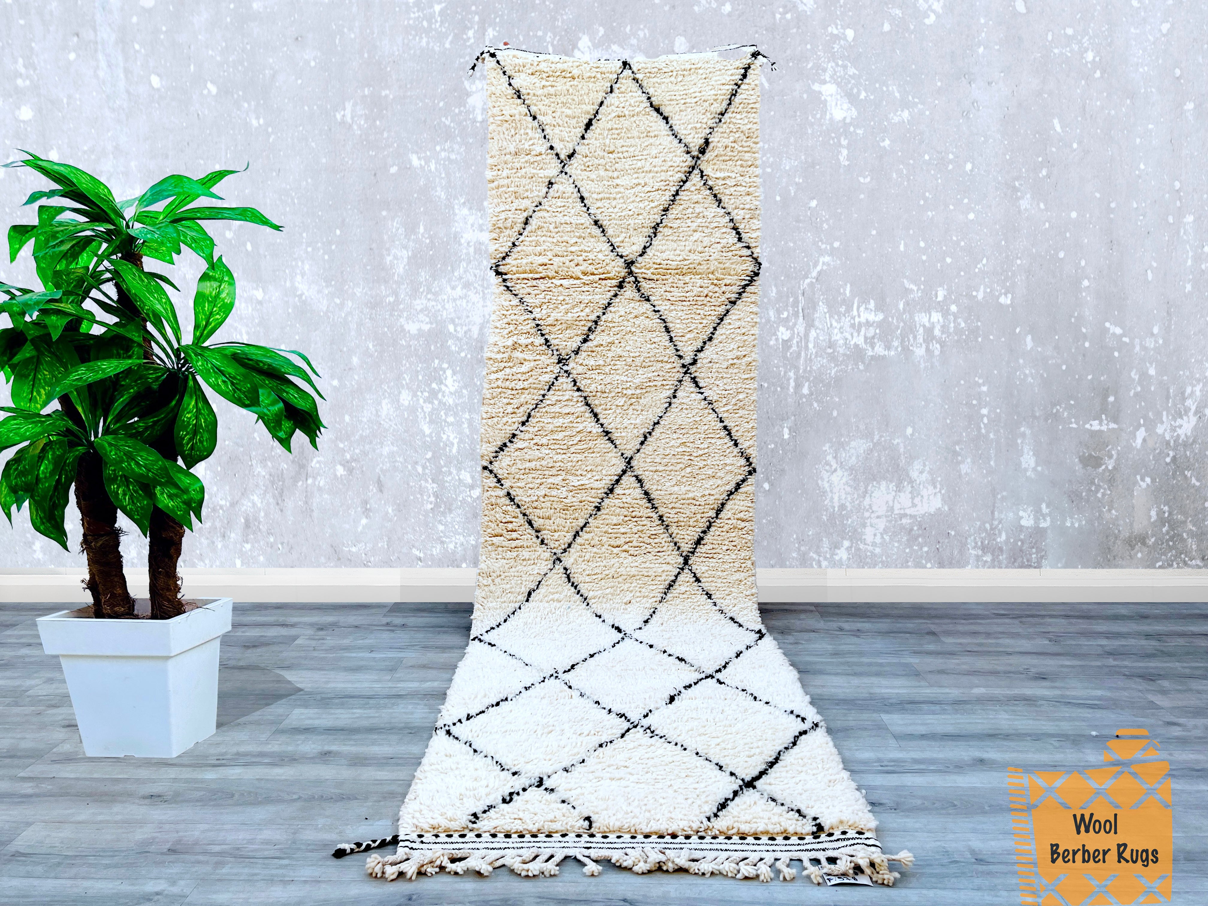 Bring timeless elegance to your home with this hand-knotted Moroccan Beni Ourain runner rug. Measuring 2.7 FT x 10.0 FT, this Berber wool carpet showcases a vintage black and white tribal motif, perfect for hallways, living rooms, or bedrooms. Each rug is individually handmade, ensuring a unique piece with slight variations that highlight its artisanal craftsmanship. The premium wool material offers a soft, cozy feel while being durable enough for daily use. Whether you're decorating a boho, Scandinavian, o