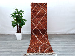Enhance your home with this long Moroccan Beni Ourain runner rug, featuring a classic black-and-white tribal design. Measuring approximately 3x9 ft, this handmade wool rug is perfect for hallways, kitchens, or living rooms. The Berber craftsmanship ensures a soft yet durable texture, while the vintage-inspired patterns add a touch of bohemian elegance. Made from natural wool, this Moroccan carpet is eco-friendly and non-shedding, making it ideal for high-traffic spaces. Whether layered over hardwood or used