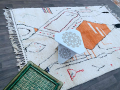 Discover the beauty of Moroccan artistry with this authentic Azilal Berber rug, meticulously handwoven by tribal artisans. Its rich colors and abstract designs reflect the natural landscapes and cultural heritage of the Atlas Mountains. Made from genuine wool, this rug is soft yet resilient, perfect for high-traffic areas. Whether layered in a bohemian setup or used as a standalone statement piece, its versatile charm suits any interior style. A perfect blend of tradition and modern aesthetics, this rug is