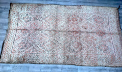 Enhance your decor with this authentic Berber tribal rug, a masterpiece of Moroccan craftsmanship. Featuring a bold red hue and traditional patterns, this vintage wool rug exudes warmth and cultural richness. Perfect for large spaces, it effortlessly anchors a room, adding depth and sophistication. The handmade distressed finish gives it a unique, lived-in charm, making it ideal for boho, eclectic, or mid-century modern interiors. Crafted from natural wool, this luxurious Moroccan carpet is both durable and