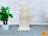 Bring timeless Moroccan craftsmanship into your home with this vintage pink Beni Ourain runner rug. Measuring 2.7 x 8.3 ft, this handwoven wool rug features a soft, shaggy texture and subtle geometric motifs, perfect for hallways, entryways, or as a stylish bedroom accent. The pale pink and cream tones create a warm, inviting look, while the high-quality wool ensures long-lasting comfort underfoot. Each rug is individually handmade by skilled Berber weavers, making every piece unique. Whether layered over h