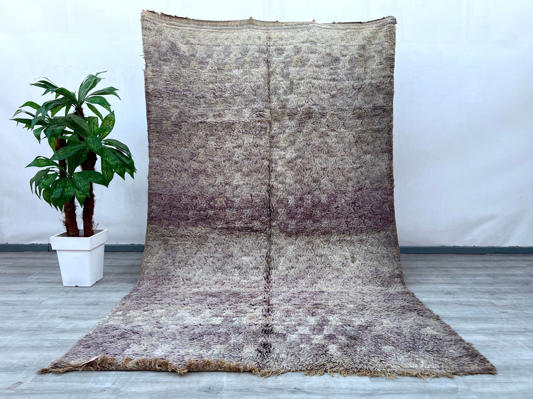 Enhance your space with this stunning Boujad Moroccan rug, a true testament to traditional craftsmanship. Handmade using premium wool, this rug features a rich, faded design with intricate tribal motifs, offering a perfect balance of vintage charm and modern appeal. The distressed, overdyed finish gives it a one-of-a-kind look, while the soft, neutral tones effortlessly complement any décor. Whether placed in a living room, dining area, or bedroom, this handwoven Berber carpet adds warmth, texture, and cult