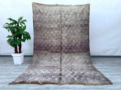 Enhance your space with this stunning Boujad Moroccan rug, a true testament to traditional craftsmanship. Handmade using premium wool, this rug features a rich, faded design with intricate tribal motifs, offering a perfect balance of vintage charm and modern appeal. The distressed, overdyed finish gives it a one-of-a-kind look, while the soft, neutral tones effortlessly complement any décor. Whether placed in a living room, dining area, or bedroom, this handwoven Berber carpet adds warmth, texture, and cult