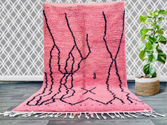 Elevate your home decor with this handmade Moroccan Azilal rug, a stunning Berber wool carpet featuring vibrant colors and geometric motifs. Woven by skilled artisans, this tribal-inspired rug combines soft textures with durable craftsmanship, making it perfect for high-traffic areas. The bohemian design adds an exotic touch to any room, whether placed in a living room, entryway, or bedroom. Each piece tells a story through its unique patterns and natural wool fibers, ensuring no two rugs are alike. A timel