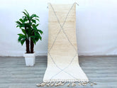 Elevate your space with this authentic handmade Beni Ourain runner rug, meticulously woven by Berber artisans in Morocco. Measuring 3x9 feet, this vintage-inspired hallway rug features a plush wool pile in creamy ivory with subtle geometric diamond patterns, adding timeless bohemian charm. The 100% natural sheep wool ensures durability and softness underfoot, while the neutral tones blend seamlessly with modern, rustic, or eclectic decor. Perfect for high-traffic areas, this tribal Berber carpet brings warm