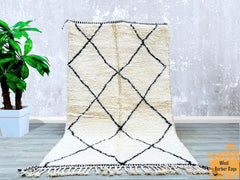 Bring organic texture and artisanal charm into your home with this bohemian-inspired Beni Ourain-style rug. Made from premium natural wool, this hand-knotted carpet offers a plush, shaggy feel underfoot, ideal for creating a cozy, inviting atmosphere. The subtle ivory and black tribal motifs provide a versatile foundation for both contemporary and vintage interiors. Whether used as a statement piece in a minimalist setting or layered with other textiles for a boho-chic look, this authentic Moroccan-inspired