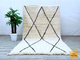 Enhance your space with a bohemian Moroccan rug, featuring intricate Berber designs and plush wool craftsmanship. This hand-knotted vintage carpet showcases tribal patterns that tell a story of Moroccan heritage, adding a touch of global charm to your home. The soft, thick pile provides luxurious comfort, while the neutral tones effortlessly complement Scandinavian, eclectic, or minimalist styles. Perfect as a statement piece in the living room, bedroom, or dining area, this eco-friendly wool rug is both du
