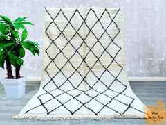 Bring warmth and character to your home with this handwoven Moroccan wool rug, inspired by traditional Berber designs. Featuring a soft, high-pile texture and a neutral cream-and-black pattern, this versatile rug complements boho, minimalist, and contemporary interiors. Made from natural wool, it offers durability and a luxurious feel, ideal for high-traffic areas. The intricate tribal motifs tell a story of heritage and craftsmanship, making each piece one-of-a-kind. Perfect for layering in living rooms, u