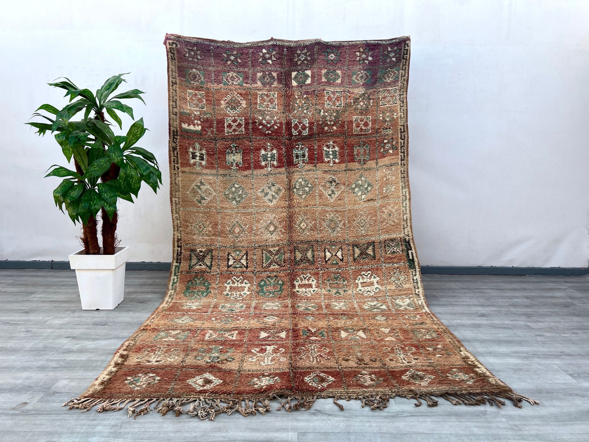 Elevate your interior with this bohemian vintage Moroccan rug, a true testament to artisanal weaving traditions. Featuring a distressed tribal design, this handmade wool carpet showcases a harmonious mix of deep reds, warm oranges, and neutral hues, creating a striking focal point. The Berber-inspired motifs add cultural depth, while the plush, high-pile texture ensures comfort underfoot. Ideal for eclectic, boho-chic, or minimalist spaces, this oriental area rug brings character and coziness to bedrooms, l