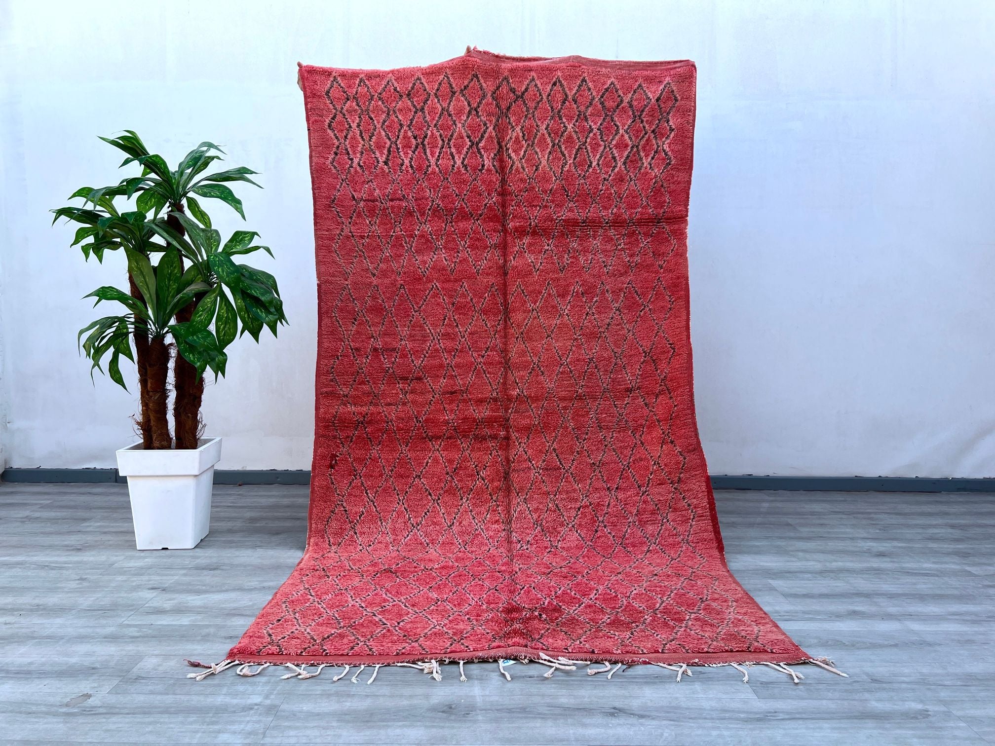 Enhance your decor with a vintage Beni Mguild Moroccan rug, a stunning hand-knotted wool carpet featuring bold geometric patterns and a luxurious texture. These tribal Berber rugs are known for their durability and timeless appeal, blending seamlessly into boho, eclectic, or minimalist interiors. The soft, high-pile wool provides comfort underfoot, making it ideal for cozy bedrooms or layered living room styling. Each rug tells a story through its handcrafted imperfections, ensuring a one-of-a-kind addition