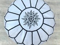 Create a custom look with an unstuffed Moroccan leather pouf cover, hand-embroidered in Marrakech. Fill it with recycled foam, cotton, or beans for a firm or plush seat. These round or hexagonal poufs (20"–24") showcase geometric patterns and natural leather aging. Lightweight and portable, they’re perfect for bohemian, global, or farmhouse styles. Wholesale options available. Authentic Moroccan Ltd and Berbere Design offer fair-trade, vegan-friendly choices.