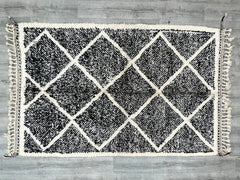Enhance your boho-inspired decor with this customizable Moroccan rug, featuring a beautiful geometric design in black and white. Handwoven using traditional Berber techniques, this wool rug is soft, durable, and adds a cozy, textured feel to any room. Whether used as a living room centerpiece, a bedroom accent, or a stylish hallway runner, its versatile pattern suits various interior styles. The natural wool fibers provide warmth and comfort, while the handmade craftsmanship ensures a one-of-a-kind piece. A