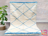Elevate your home décor with this stunning handwoven Moroccan tribal rug, featuring a captivating blue diamond motif on a creamy wool base. Inspired by traditional Berber designs, this rug adds a touch of bohemian sophistication to any room. The plush, high-quality wool ensures a soft, comfortable feel, making it ideal for cozy living spaces or stylish bedrooms. Each rug is meticulously crafted by artisans using age-old techniques, ensuring a one-of-a-kind piece with subtle variations that highlight its han