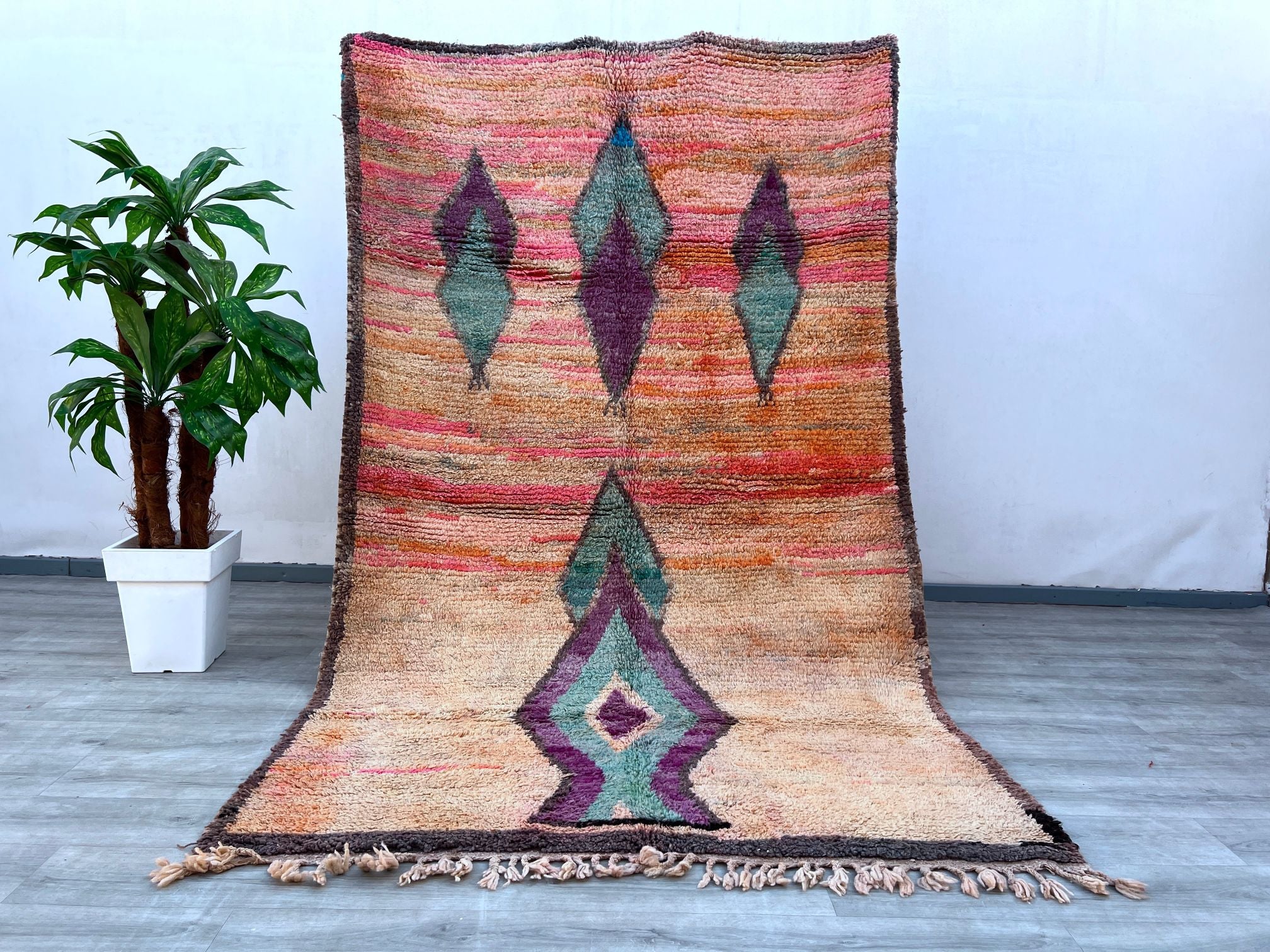 Elevate your space with this stunning vintage Moroccan runner rug, showcasing bold hues and tribal-inspired designs. Handwoven using traditional techniques, this rug features a mix of rich pinks, blues, and earthy tones, creating a striking focal point. Its durable wool construction ensures both comfort and longevity, ideal for high-traffic areas like hallways or entryways. The distressed vintage look adds character, making it a perfect fit for boho, mid-century, or global-inspired interiors. A true work of
