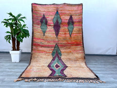 Elevate your space with this stunning vintage Moroccan runner rug, showcasing bold hues and tribal-inspired designs. Handwoven using traditional techniques, this rug features a mix of rich pinks, blues, and earthy tones, creating a striking focal point. Its durable wool construction ensures both comfort and longevity, ideal for high-traffic areas like hallways or entryways. The distressed vintage look adds character, making it a perfect fit for boho, mid-century, or global-inspired interiors. A true work of