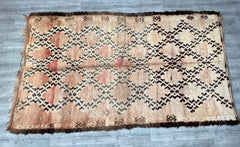 Transform your interiors with this handmade vintage Moroccan rug, featuring a beautifully faded, distressed pattern that exudes boho sophistication. Woven by artisans using natural wool, this rug boasts a plush, durable texture with a unique overdyed finish, ensuring no two pieces are alike. The tribal-inspired motifs and neutral tones make it versatile for various décor styles, from bohemian to minimalist. Perfect as a statement area rug, this authentic Berber carpet brings warmth, history, and artistic fl