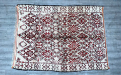 Enhance your home with a stunning vintage Moroccan Berber rug, meticulously handwoven by skilled artisans. This authentic Boujad carpet features a rich blend of red, ivory, and earthy tones, showcasing intricate tribal patterns that tell a story of tradition. Crafted from natural wool, this 6x10 ft Moroccan rug adds warmth and texture to any space—perfect for living rooms, bedrooms, or bohemian-inspired interiors. The distressed vintage finish gives it a timeless appeal, while the durable hand-knotted const