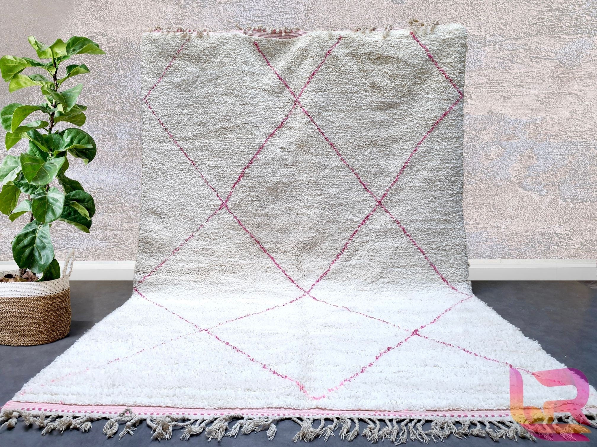 Elevate your home with this stunning handmade pink Moroccan rug, crafted from premium wool for unmatched softness and durability. Featuring traditional Berber designs, this Beni Ourain-inspired piece blends bohemian charm with timeless elegance. Perfect for living rooms, bedrooms, or hallways, its intricate diamond patterns and plush texture add warmth to any space. Each rug is meticulously hand-knotted by skilled artisans, ensuring a unique, high-quality finish. The delicate pink hues create a cozy yet sty