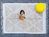 Bring timeless elegance to your space with this hand-knotted Moroccan Berber rug, crafted by skilled artisans using 100% natural wool. Measuring 7x10ft, this Azilal-style rug features intricate tribal patterns and a soft, plush texture, perfect for living rooms, bedrooms, or boho-chic interiors. Each rug is unique, showcasing traditional Berber designs with neutral tones that blend seamlessly into modern and rustic décor. The Beni Ourain-inspired geometric motifs add warmth and character, while the durable