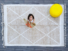 Bring timeless elegance to your space with this hand-knotted Moroccan Berber rug, crafted by skilled artisans using 100% natural wool. Measuring 7x10ft, this Azilal-style rug features intricate tribal patterns and a soft, plush texture, perfect for living rooms, bedrooms, or boho-chic interiors. Each rug is unique, showcasing traditional Berber designs with neutral tones that blend seamlessly into modern and rustic décor. The Beni Ourain-inspired geometric motifs add warmth and character, while the durable