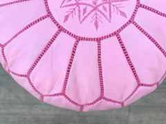 Elevate your living space with a handmade Moroccan leather pouf, crafted using traditional techniques by skilled artisans. Made from genuine goat or buffalo leather, each pouf features intricate hand-stitched embroidery, adding a bohemian touch to any room. Perfect as a footstool, extra seating, or decorative accent, these leather ottomans are available in round, square, and oversized designs. Choose between filled or unfilled options for customizable comfort. Whether you prefer a brown, tan, or deep orange