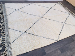Discover the beauty of a handmade Beni Ourain-style rug, a plush, ultra-soft wool carpet inspired by traditional Moroccan weaving techniques. Featuring a subtle diamond or zig-zag pattern, this bohemian area rug is perfect for adding cozy texture to modern and rustic spaces. The natural wool fibers provide durability and comfort underfoot, making it ideal for high-traffic areas like living rooms and bedrooms. Whether layered over hardwood floors or used as a statement wall hanging, this Berber-inspired rug