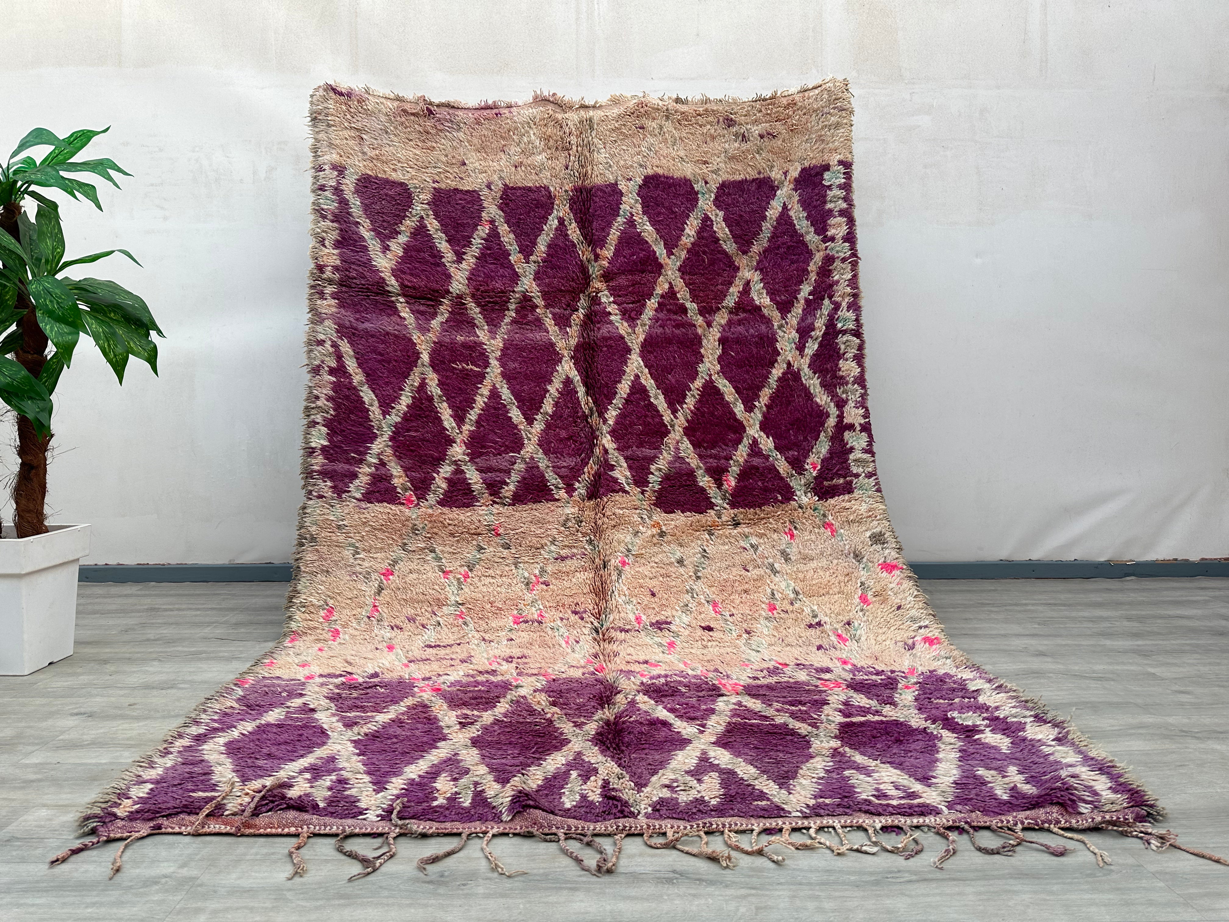 Discover the beauty of this handmade boho rug, a vintage wool carpet featuring a mesmerizing blend of purple, pink, and earthy tones. Designed with abstract patterns, this authentic Berber rug is a testament to artisanal craftsmanship, offering both durability and timeless appeal. Perfect for boho home decor, this handwoven wool rug adds texture and warmth to any space. Its vintage abstract carpet design complements mid-century, eclectic, or minimalist interiors, making it a versatile statement piece. Each
