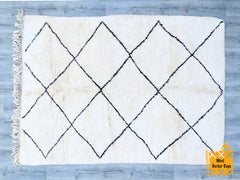 Bring timeless elegance to your home with this handmade Moroccan Beni Ourain rug, crafted by skilled Berber artisans. Woven from natural wool, this authentic piece features a minimalist black-and-white geometric design, perfect for adding warmth and texture to any space. The soft, plush pile ensures comfort underfoot, making it ideal for living rooms, bedrooms, or cozy reading nooks. Each rug is unique, showcasing traditional craftsmanship with subtle variations that highlight its handmade charm. Whether yo