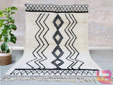 Elevate your home with a handmade Moroccan Beni Ourain rug, crafted from natural wool by skilled Berber artisans. This authentic tribal rug features a soft, plush texture and a timeless black-and-white geometric design, perfect for modern and boho interiors. Each custom Moroccan carpet is hand-knotted, ensuring durability and unique artistry. Whether used as a living room centerpiece or a bedroom accent, this wool Berber rug adds warmth and elegance. Free shipping available for a seamless shopping experienc