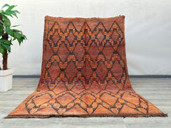 Crafted by skilled artisans, this handmade tribal wool rug features a striking checkered and diamond pattern, blending traditional weaving techniques with a contemporary aesthetic. The warm, earthy tones and intricate geometric details create a visually captivating piece that enhances any room. Made from natural wool, it offers both durability and softness underfoot, making it perfect for high-traffic areas. The faded vintage finish adds a rustic, well-worn appeal, ideal for shabby-chic, farmhouse, or eclec