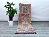 A stunning handmade vintage Turkish runner (3x9 ft / 278x82 cm) featuring tribal geometric patterns in rich red, beige, and water-green hues. Woven with high-quality wool, this Anatolian rug boasts a 70-year-old floral design with vibrant vegetable dyes. Its durable construction and distressed texture reflect authentic craftsmanship, making it perfect for high-traffic areas like hallways or kitchens. The bohemian aesthetic pairs effortlessly with modern or traditional decor. Free shipping included. A rare f