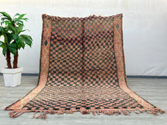Enhance your space with this vibrant vintage checkered Moroccan rug, showcasing a beautiful blend of pink, brown, and black tribal patterns. Crafted by skilled artisans, this Berber-style rug features a mix of geometric motifs and a plush, textured feel. Ideal for layering or as a standalone statement, it adds warmth and character to bedrooms, living rooms, or dining areas. The distressed, wabi-sabi aesthetic gives it a well-loved, timeless appeal, perfect for those who appreciate handmade, one-of-a-kind de