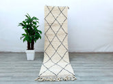 Elevate your space with this authentic handmade Beni Ourain Moroccan runner rug, crafted by Berber artisans using traditional techniques. Measuring 2.7 FT x 10 FT, this vintage-style hallway runner features a soft wool blend in a timeless black-and-white geometric pattern, perfect for adding boho-chic charm to entryways, living rooms, or bedrooms. The natural, undyed wool ensures durability and a plush texture, while the hand-knotted design reflects Morocco’s rich weaving heritage. Ideal for bohemian, minim