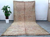 Transform your home into a cozy sanctuary with this large vintage Moroccan rug, featuring a stunning distressed design and a warm, faded palette. Handwoven by Berber tribes using traditional techniques, this luxurious wool rug showcases intricate geometric motifs that add depth and texture to any room. Ideal for spacious living areas, bedrooms, or even as a statement hallway runner, this boho-inspired carpet brings a rustic yet refined charm. The natural fibers ensure durability, while the soft pile offers