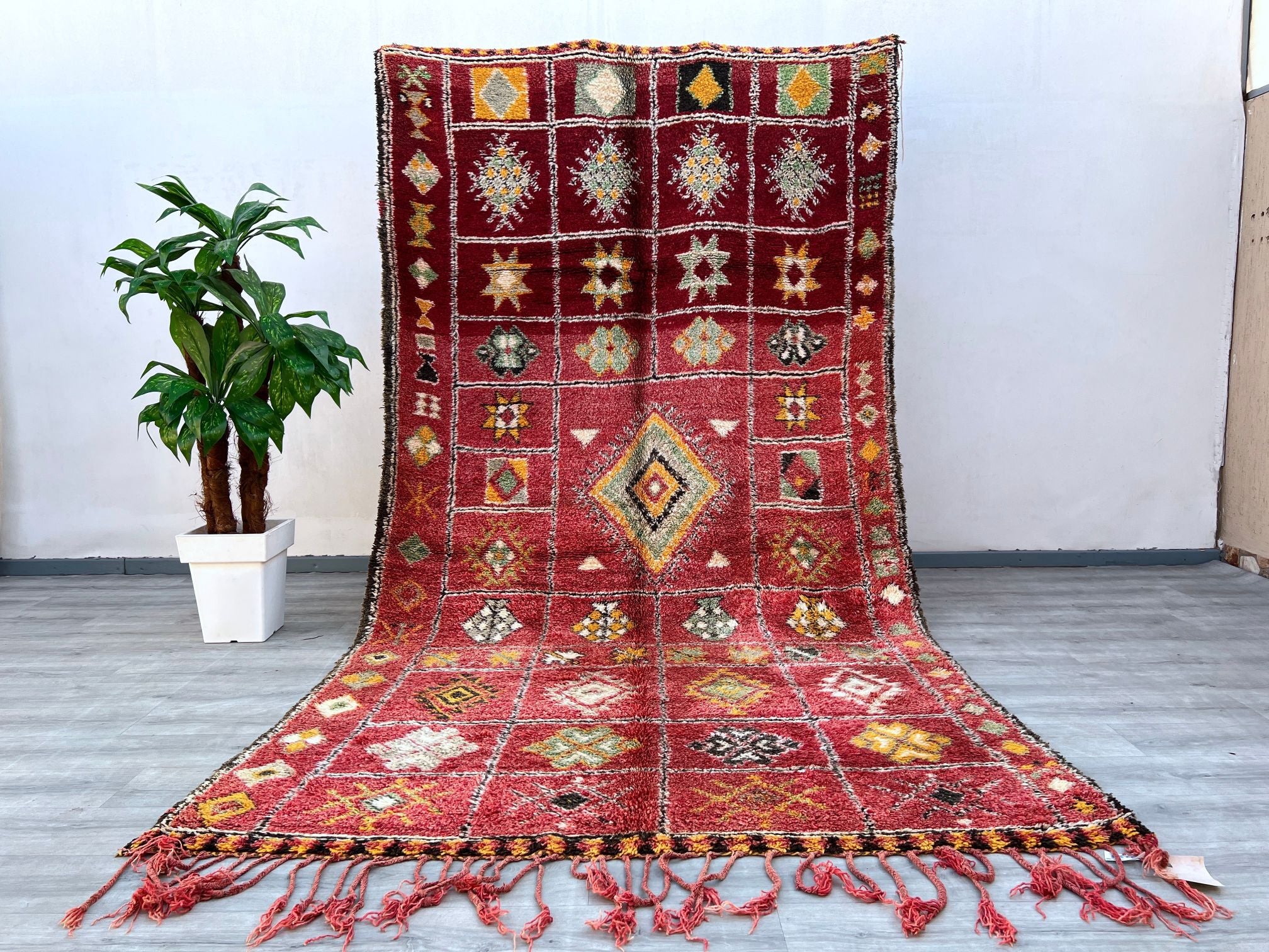 Enhance your decor with this vintage Berber rug, a handmade Moroccan wool carpet featuring rich textures and faded tribal motifs. Measuring 6x12 ft, this Boujad-style rug is crafted using traditional techniques, offering a soft, durable, and timeless addition to your home. The bohemian-inspired design blends seamlessly with modern, farmhouse, or global decor styles, making it a versatile choice for living areas, dining rooms, or entryways. Each rug tells a story through its organic imperfections and natural