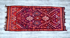 Elevate your space with this handmade vintage Boujaad rug, a Moroccan tribal masterpiece featuring bold geometric designs and a lush wool pile. Its muted rose, terracotta, and ivory hues blend seamlessly with modern, rustic, or eclectic decor. Woven by Berber women using centuries-old techniques, this 6x9 ft rug is both durable and soft underfoot. The distressed vintage finish adds authenticity, while the ethnic motifs pay homage to Morocco’s artisan traditions. A perfect investment piece for boho chic, mid