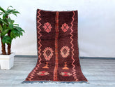 Elevate your décor with this oversized vintage Moroccan rug, hand-knotted for durability and timeless appeal. The 5x9 ft dimensions make it ideal for anchoring living rooms or dining spaces, while the distressed tribal patterns—featuring diamonds, stripes, and symbolic Berber motifs—add cultural depth. Woven from 100% natural wool, this rug boasts a plush yet sturdy texture, with a faded burgundy, ivory, and terracotta color scheme for warmth. Its slightly irregular edges and muted tones highlight its artis