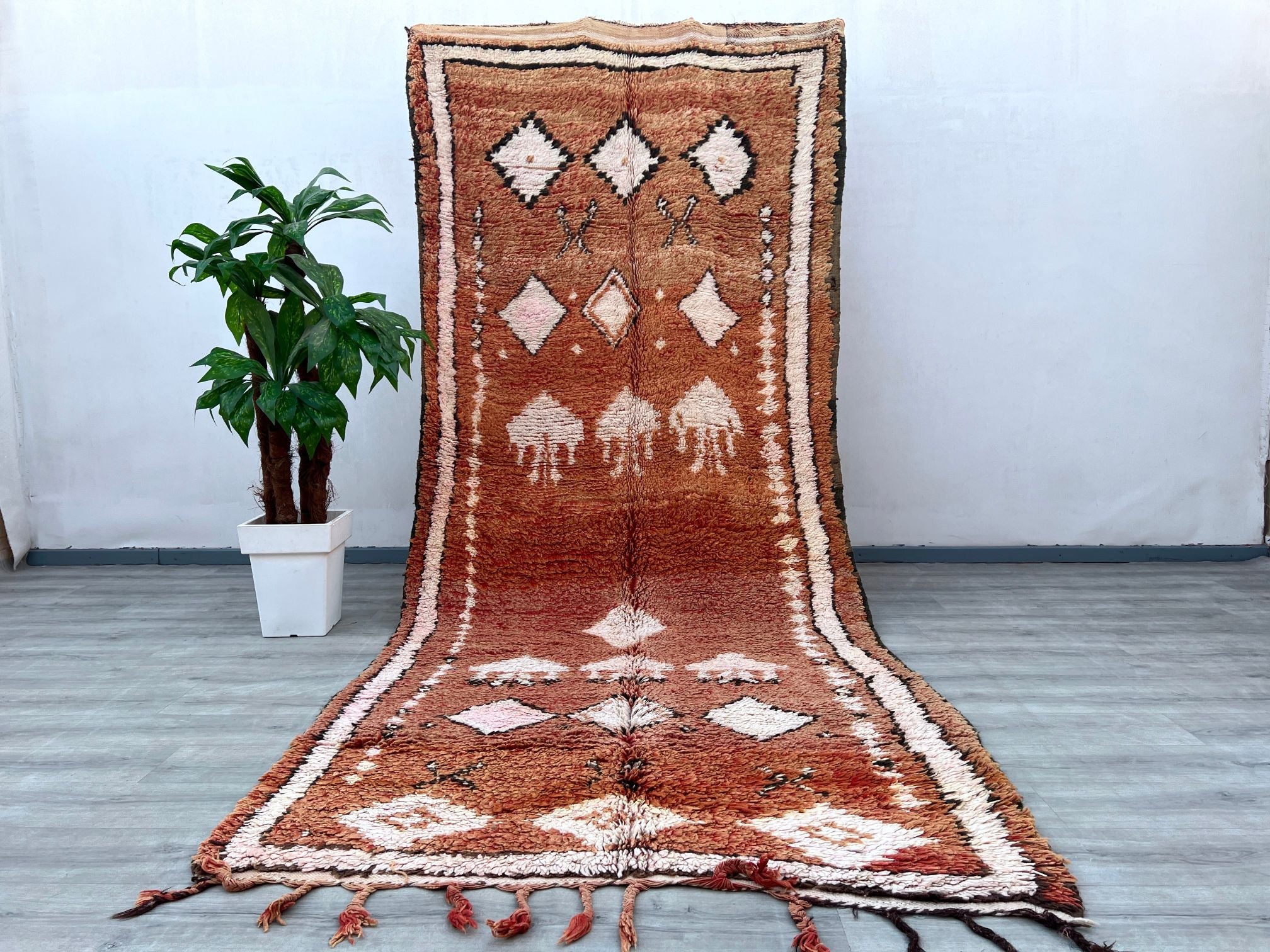 Elevate your home with this stunning 6x12 ft vintage Moroccan tribal rug, a masterpiece of Berber artistry. Hand-knotted from natural wool, this rug features intricate geometric motifs and a plush pile, offering both comfort and durability. The earthy tones and tribal patterns make it versatile for boho, farmhouse, or eclectic decor styles. Perfect as a statement area rug or a luxurious living room centerpiece, this authentic Moroccan carpet is ethically handmade using age-old techniques. Its distressed vin