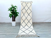 Enhance your home with this long Moroccan Beni Ourain runner rug, featuring a classic black-and-white tribal design. Measuring approximately 3x9 ft, this handmade wool rug is perfect for hallways, kitchens, or living rooms. The Berber craftsmanship ensures a soft yet durable texture, while the vintage-inspired patterns add a touch of bohemian elegance. Made from natural wool, this Moroccan carpet is eco-friendly and non-shedding, making it ideal for high-traffic spaces. Whether layered over hardwood or used