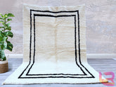 Enhance your interior with this luxurious cream wool Berber rug, a perfect fusion of style and comfort. Handcrafted using natural wool, this Moroccan-inspired carpet features a plush, shaggy texture for a cozy underfoot feel. The neutral cream tones and subtle black tribal motifs create a versatile, minimalist aesthetic that complements any décor. Whether placed in a boho-chic living room or a serene bedroom, this handwoven area rug adds warmth and elegance. Ethically made and durable, it’s an ideal choice