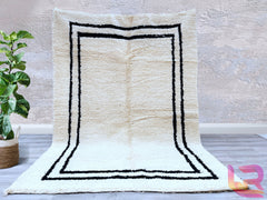 Enhance your interior with this luxurious cream wool Berber rug, a perfect fusion of style and comfort. Handcrafted using natural wool, this Moroccan-inspired carpet features a plush, shaggy texture for a cozy underfoot feel. The neutral cream tones and subtle black tribal motifs create a versatile, minimalist aesthetic that complements any décor. Whether placed in a boho-chic living room or a serene bedroom, this handwoven area rug adds warmth and elegance. Ethically made and durable, it’s an ideal choice