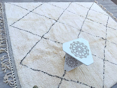 Elevate your interior with a minimalist Beni Ourain carpet, a handwoven wool rug featuring clean lines and subtle texture. This authentic Moroccan Berber rug is crafted from premium natural wool, offering unmatched softness underfoot. The black and white abstract designs create a modern yet timeless look, perfect for contemporary, farmhouse, or mid-century spaces. Each piece is one-of-a-kind, reflecting the artisan’s heritage through delicate craftsmanship. Whether placed in a living room, bedroom, or hallw