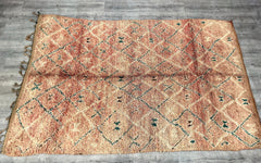 Discover the artistry of Moroccan weaving with this authentic vintage Boujaad rug, a 6x11-foot handwoven treasure from the heart of Berber culture. Adorned with tribal patterns in muted tones of rust, cream, and indigo, this rug exudes rustic elegance and timeless appeal. Crafted from natural, undyed wool, it boasts a sturdy yet plush feel, suitable for both floor decor and wall hangings. The Boujaad tribal design is revered for its raw, organic aesthetic, making each piece uniquely imperfect. Ideal for boh