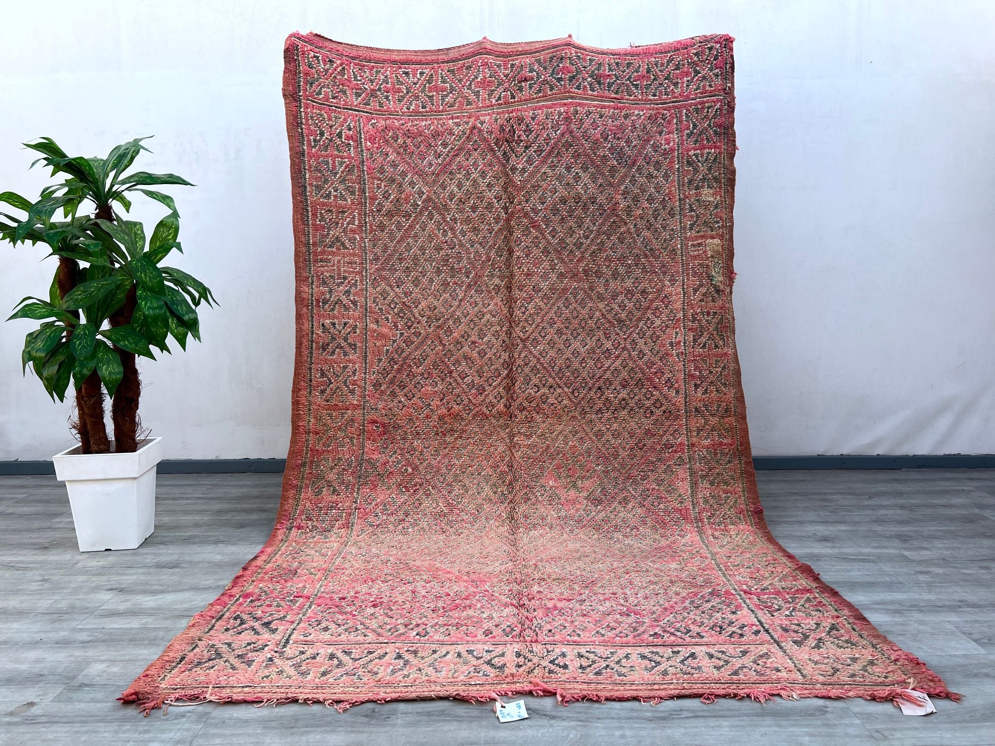 Enhance your décor with this vintage pink Moroccan rug, a beautiful handwoven Beni Mguild carpet featuring rich textures and faded hues. Each piece tells a story through its tribal motifs and artisanal craftsmanship, making it a perfect addition to bohemian, mid-century, or minimalist interiors. Made from natural wool, this rug is soft underfoot while maintaining durability for high-traffic areas. Whether placed in a bedroom, lounge, or entryway, its warm, earthy tones create a cozy and inviting atmosphere,